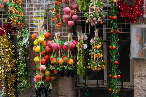 Strings of brightly colored, plastic fruits are sold on a street in Jerusalem and used to decorate the sukkah during the Jewish holiday of sukkot. photo