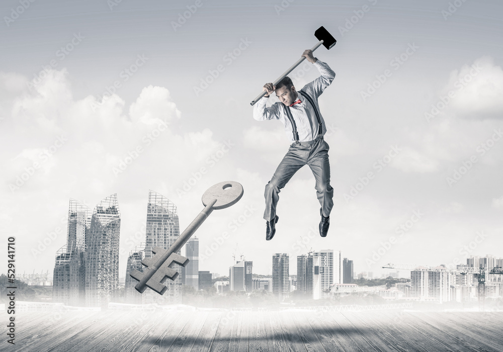 Breaking through access concept with man in anger crashing concrete key