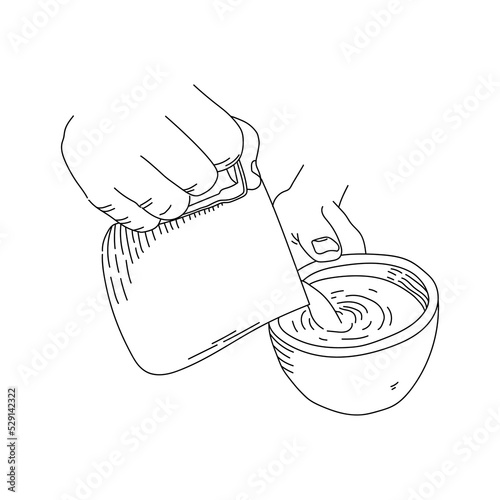 Hands pouring creamer milk on a glass of coffee, isolated on white background.