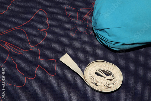 blue bolster and strap on yoga mat