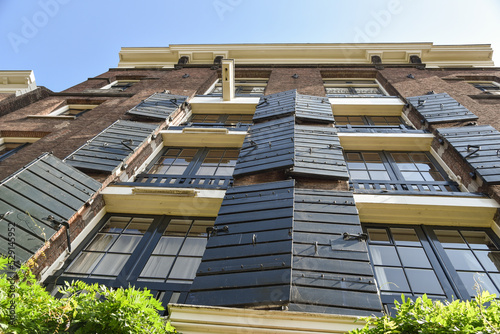 Amsterdam, Netherlands. August 2022. The facade of a warehouse with the shutters and the hoisting beam.