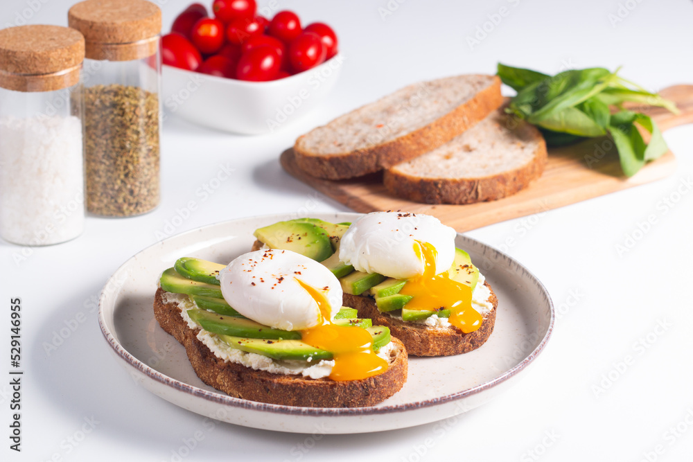 Two avocado open sandwiches with egg. Keto and diet concept. Healthy toast food for breakfast. Two avocado open sandwiches with egg. Keto and diet concept. Healthy toast food for breakfast.
