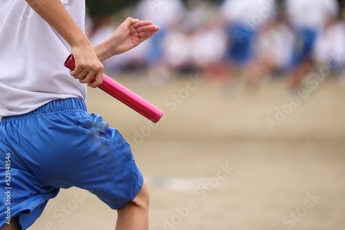 運動会、リレーのバトンを持つ手 photo