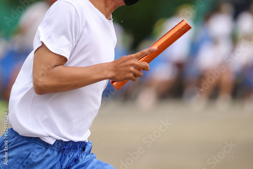 運動会、リレーのバトンを持つ手