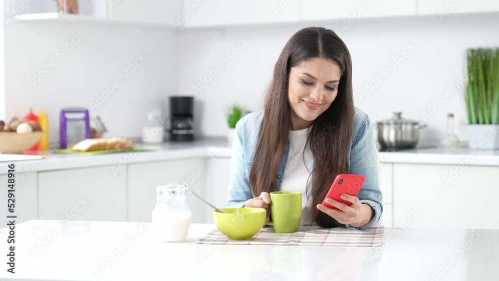 Lady sit kitchen table drink espresso answer smart gadget call in apartment Lady sit kitchen table drink espresso answer smart gadget call in apartment