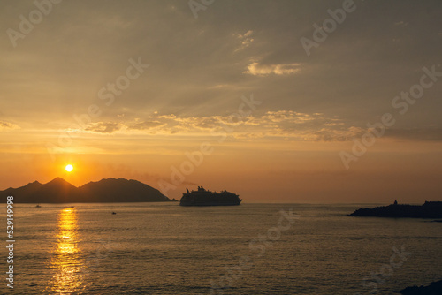 Puesta de sol con un gran trasatlántico navegando cerca de la costa. Ría de Vigo, Galicia, España