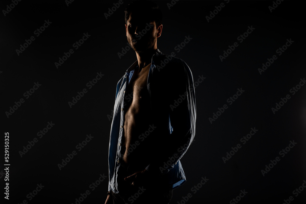 Male model posing in a light dimmed room Male model posing in a light dimmed room