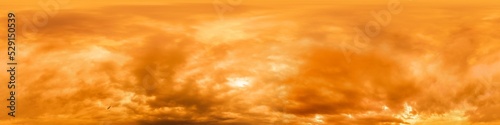 Golden glowing red orange overcast sunset sky panorama. Hdr seamless spherical equirectangular 360 panorama. Sky dome or zenith for 3D visualization and sky replacement for aerial drone 360 panoramas. © panophotograph