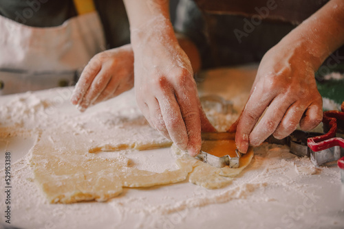 Closeup view on hands how mother with son preparing flour for cookies in the kitchen
