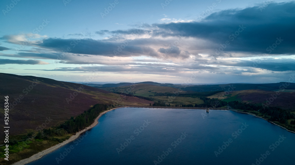 a colourful sky and an aerial picture of a water reservoir at dusk. a colourful sky and an aerial picture of a water reservoir at dusk.