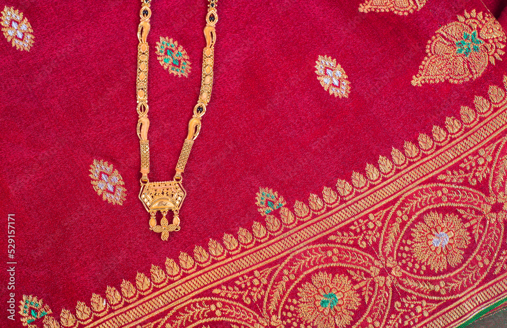 Mangalsutra or Golden Necklace to wear by a married hindu women, arranged with traditional saree with haldi, kumkum and flowers on plate. Mangalsutra or Golden Necklace to wear by a married hindu women, arranged with traditional saree with haldi, kumkum and flowers on plate.
