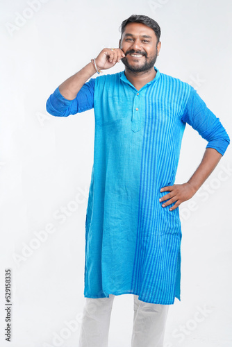Indian man in tradition wear and giving expression on white background.