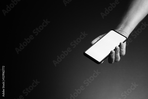 Hand holding smart phone in palm with blank white screen and copy space