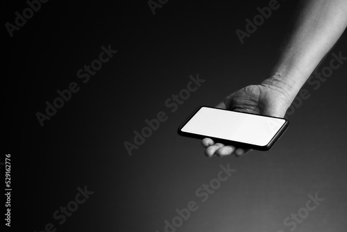 Hand holding smart phone in palm and copy spacewith blank white screen photo