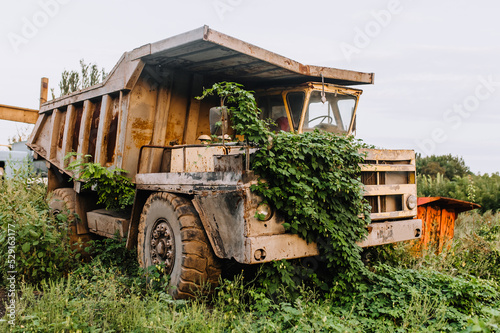Quadro em tela Old, broken, dirty, rusty abandoned car big truck, overgrown with green grass, ivy stands outdoors