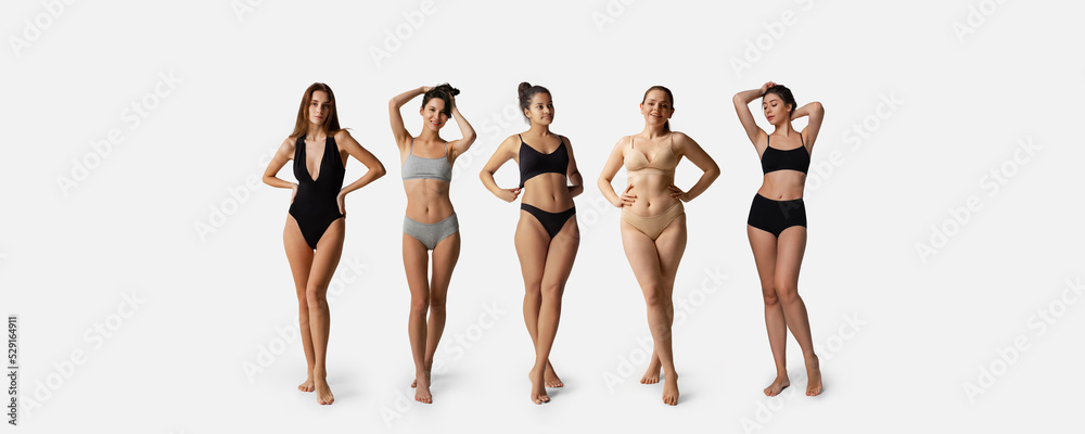 Five young women wearing underwear standing together isolated over gray background. Body positivity and weight loss concept - obrazy, fototapety, plakaty 