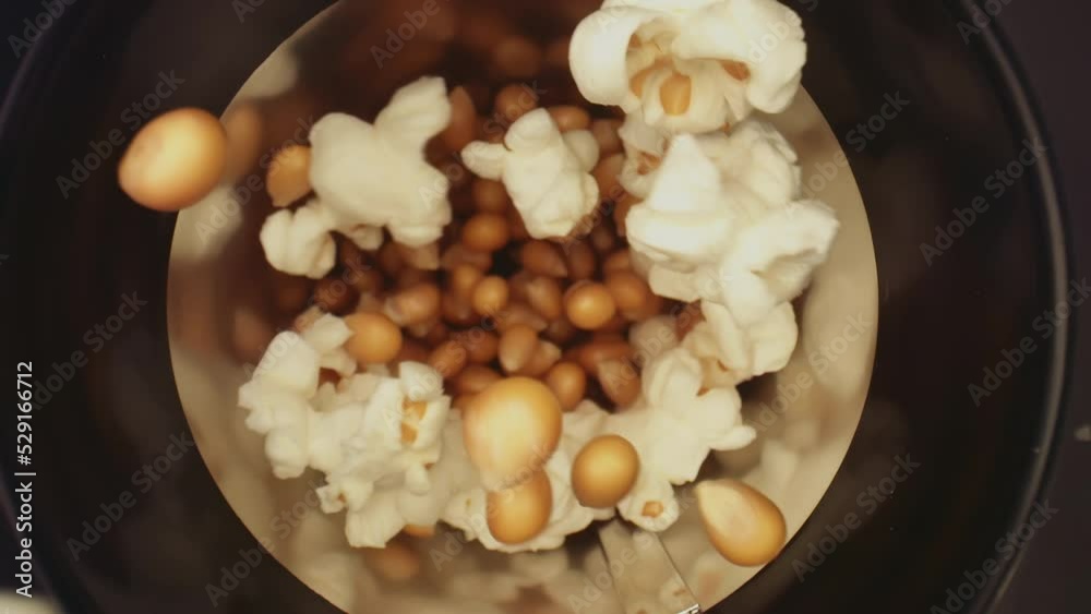 Macro slow-motion top view of popcorn popping out of the heater