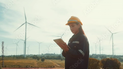 a woman engineer is wearing a protective helmet on her head, using tablet Analytics engineering data..