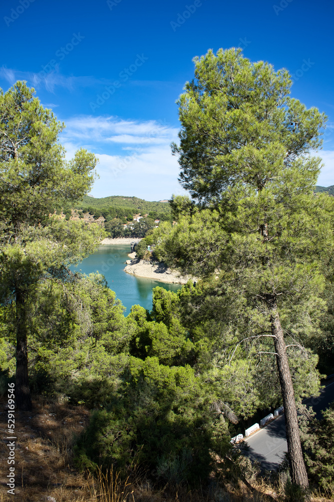 Spectacular panoramic views of the Guadalhorce reservoir, next to the Caminito del Rey in Malaga, Spain. Turquoise blue water and forest with blue sky on a sunny day. Spectacular panoramic views of the Guadalhorce reservoir, next to the Caminito del Rey in Malaga, Spain. Turquoise blue water and forest with blue sky on a sunny day.