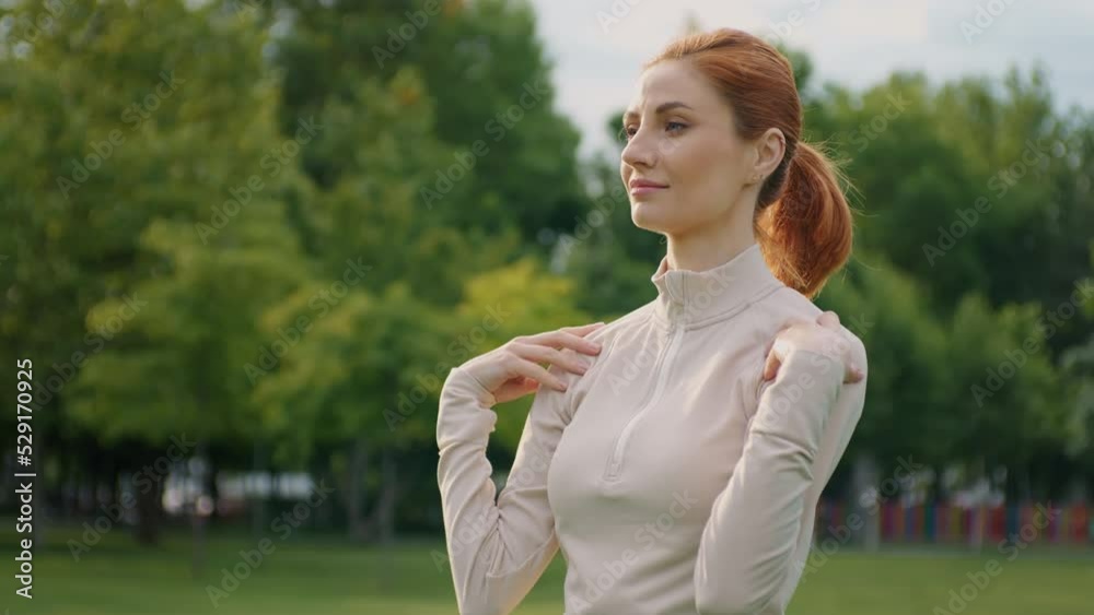 Woman training oudoors. Female starts training with warming up arms, shoulders. Morning training in the park. Woman training oudoors. Female starts training with warming up arms, shoulders. Morning training in the park.