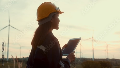 a woman engineer is wearing a protective helmet on her head, using tablet Analytics engineering data..