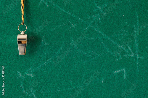 Whistle of soccer referee or trainer and soccer tactics scribble on green background, soccer template,with large copy space.Great soccer event this year