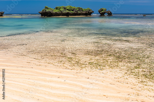 Paradise beach at low tide, crystal clear turquoise water, green islets, blue sky. photo