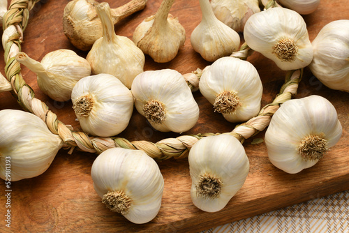 braided garlic heads and cloves on a rustic wooden background  delicious and healthy food