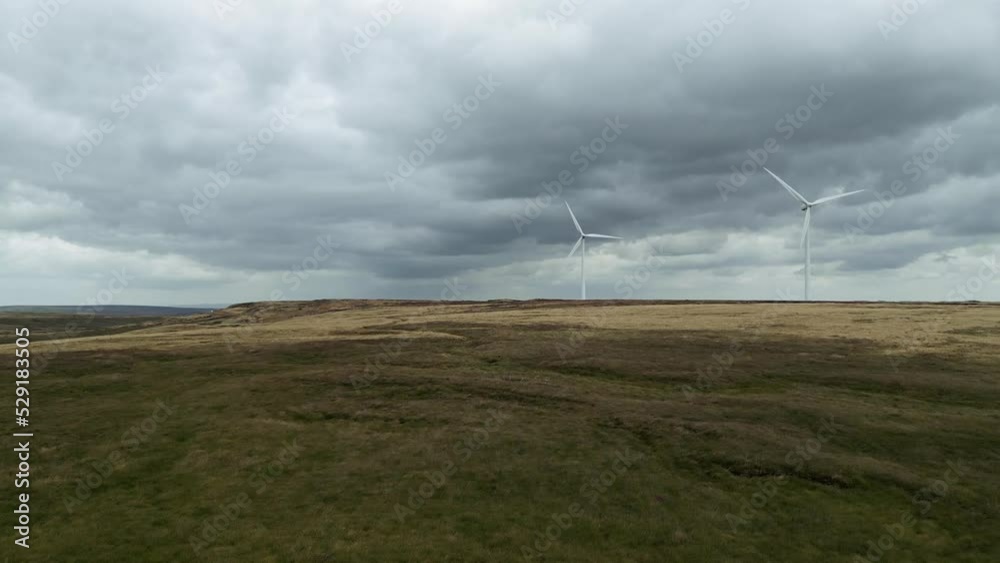 Drone aerial view of a wind farm and wind turbines turning in the wind. Footage taken at Ovenden Moor Wind Farm in the UK Drone aerial view of a wind farm and wind turbines turning in the wind. Footage taken at Ovenden Moor Wind Farm in the UK