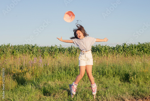 happy girl on roller skates in summer field