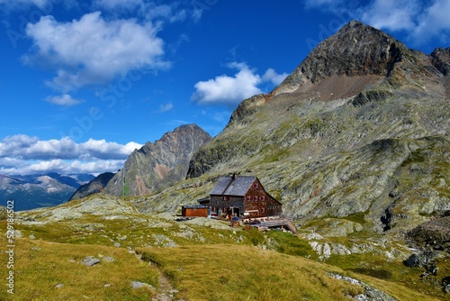 View of Adolf Noßberger Hütte and the peak of Petzeck mountain above in in Gradental valley in Schober group sub-range of Hohe Tauern in Central Eastern Alps, Carinthia, Austria photo