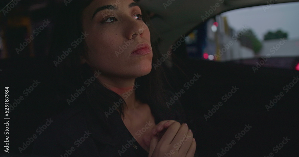 Anxious female passenger late for meeting in the backseat of a car