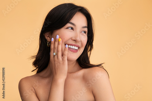 Happy Asian woman touching clean skin