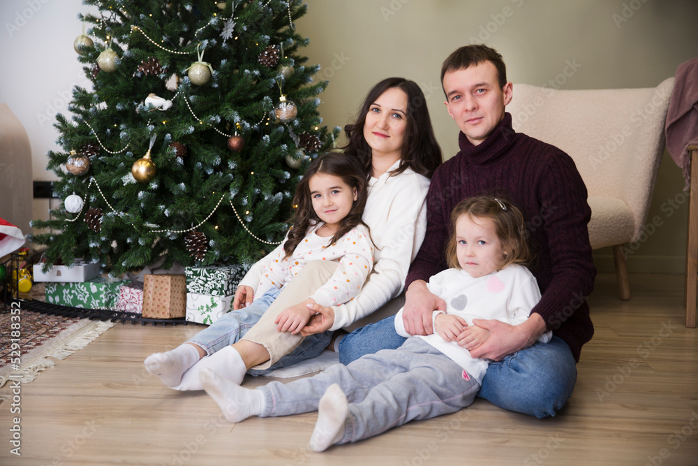 Portrait happy christmas family mom, dad and two little daughters celebrating christmas at home together Portrait happy christmas family mom, dad and two little daughters celebrating christmas at home together