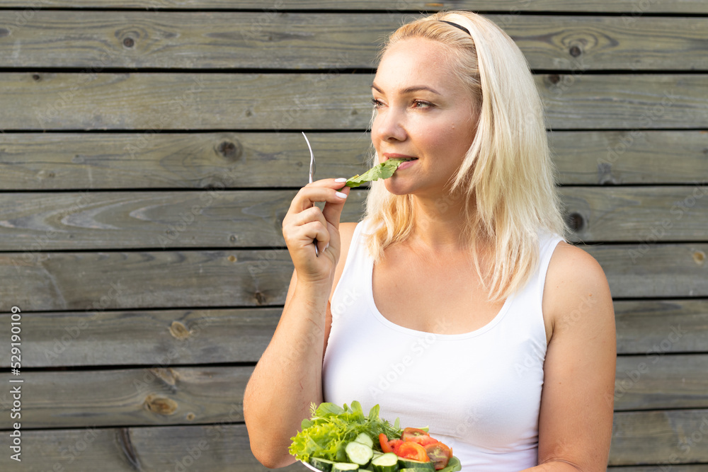 a beautiful young Woman Eats Vegetable Salad after A Workout Salad of Arugula Cucumbers And Tomatoes Healthy Eating Weight Loss Slim figure