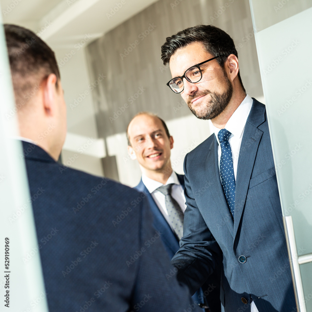 Group of confident business people greeting with a handshake at business meeting in modern office or closing the deal agreement by shaking hands. Group of confident business people greeting with a handshake at business meeting in modern office or closing the deal agreement by shaking hands.