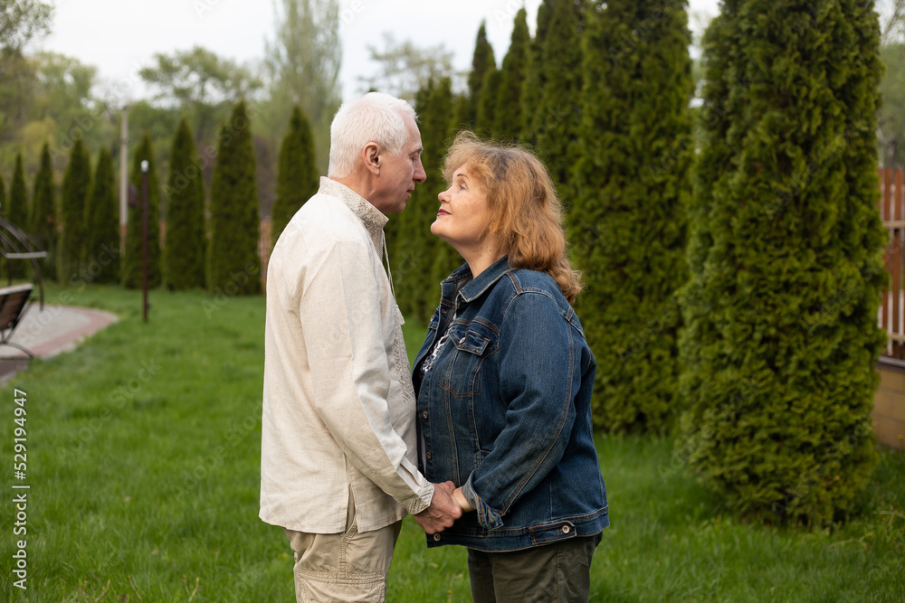 senior couple looking on each other outside in autumn or summer nature in park senior couple looking on each other outside in autumn or summer nature in park