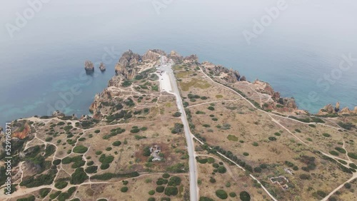 Aerial view of Ponta da Piedade lighthouse on the cliff during a beautiful day in summertime, Lagos, Algarve region, Portugal.