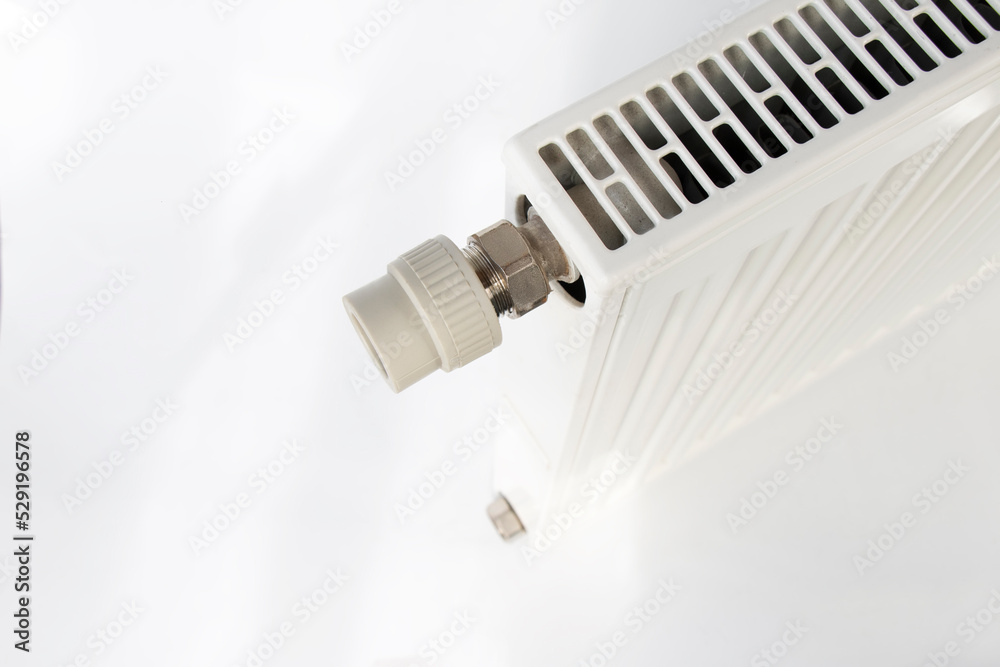 detail of a pvc fitting screwed to a heating radiator, plumbing repairman concept, on isolated white detail of a pvc fitting screwed to a heating radiator, plumbing repairman concept, on isolated white