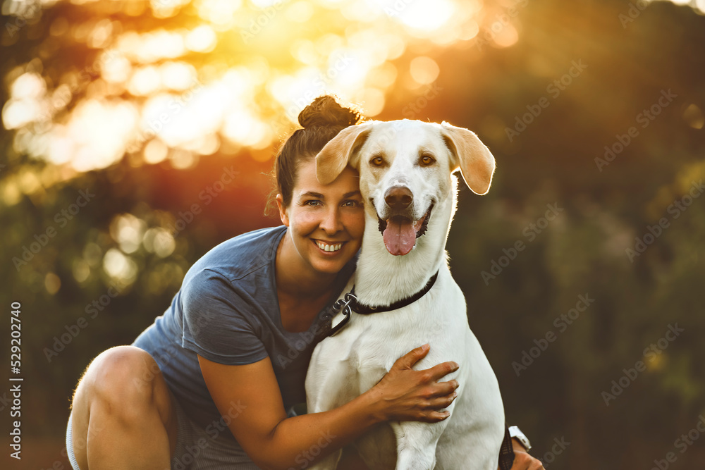 Woman and her friend dog on the Beautiful sunset background