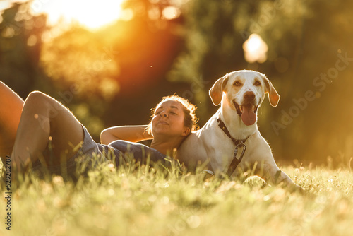 Woman and her friend dog on the Beautiful sunset background photo
