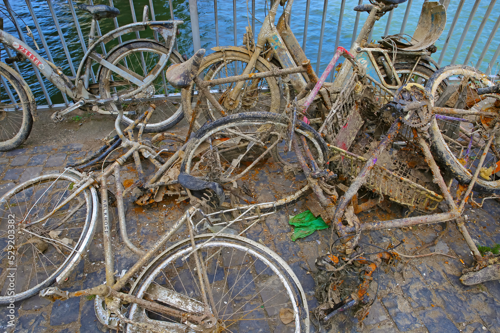 Cologne, Germany - July 9. 2022: Pile many old muddy rusty bicycles thrown into the rhine and then salvaged (focus on center) Cologne, Germany - July 9. 2022: Pile many old muddy rusty bicycles thrown into the rhine and then salvaged (focus on center)