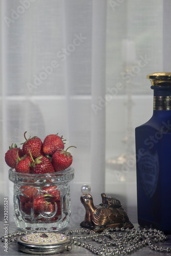 Turtle figurine, pearls and strawberries in a vase.Still life with strawberries. Crystal and unique, fresh smell of strawberries. 