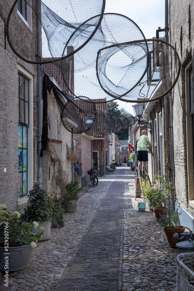 street and fishing nets, city of elburg, gelderland, veluwe, netherlands, historic medieval, cleaning the windows, 