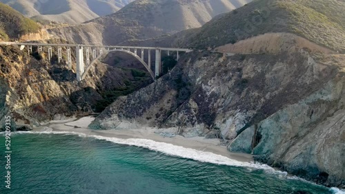 Aerial of the rugged coastline of Big Sur California. The Pacific Coast Highway and the famous Bixby Creek Bridge can be seen.