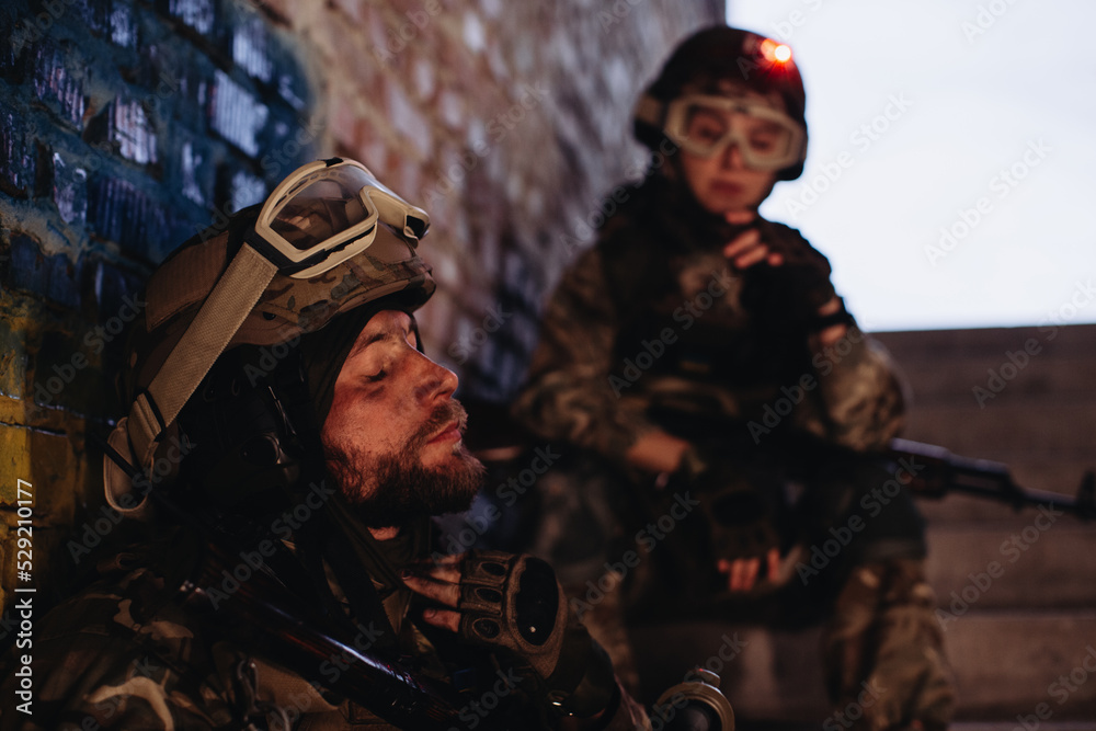 Brothers in arms resting against the background of the Ukrainian flag..Ukrainian Military in the collapsed building resting from the war.. Brothers in arms resting against the background of the Ukrainian flag..Ukrainian Military in the collapsed building resting from the war..