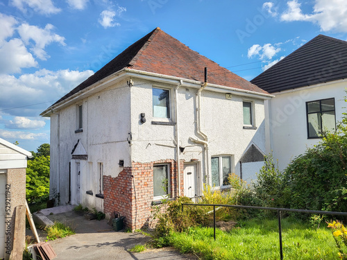 Large detached house awaiting refurbishment and improvement with driveway and cracked plaster work. 