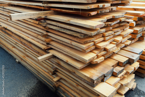Wooden boards are stacked in a sawmill or carpentry shop. Sawing drying and marketing of wood. Industrial background photo