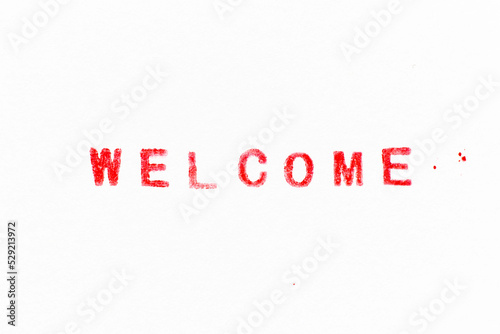 Red color ink rubber stamp in word welcome on white paper background