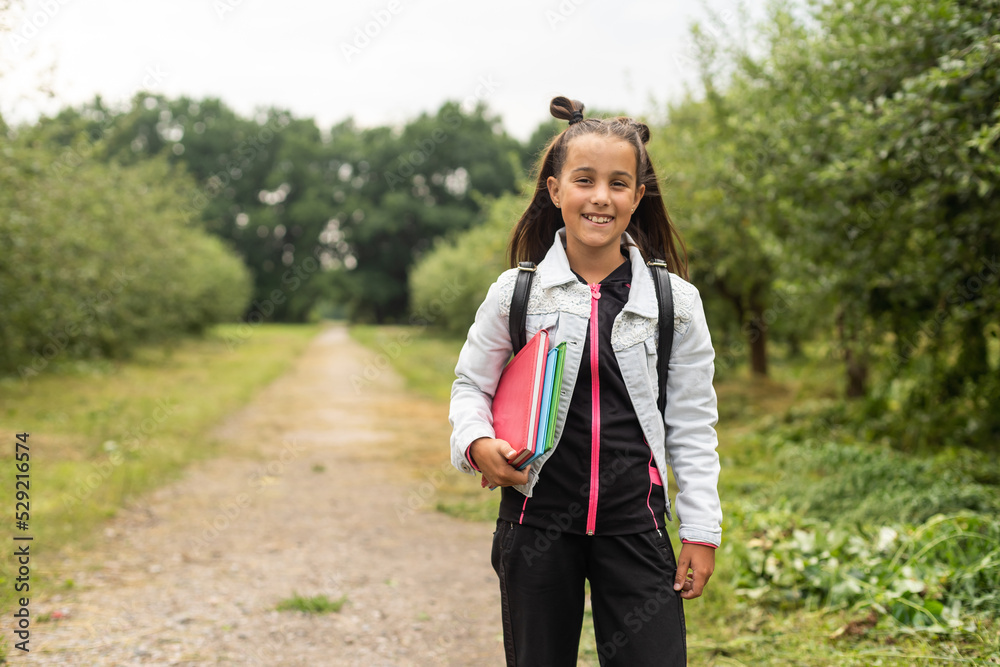 Beautiful little girl with backpack walking ready back to school, fall outdoors, education concept